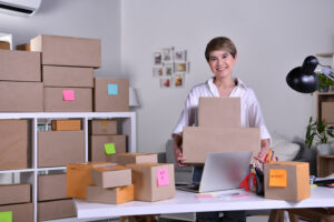 Dueña de negocio cargando cajas de sus productos, representando la temática de estrategias de fijación de precios en empresas.